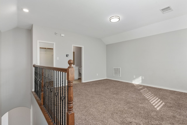 carpeted spare room with lofted ceiling