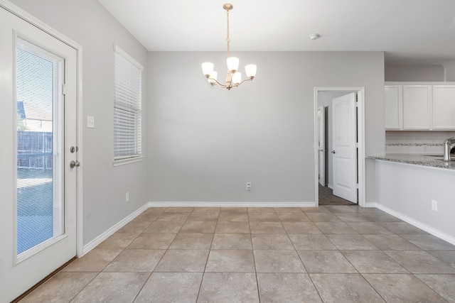 unfurnished dining area with light tile patterned flooring, sink, and a notable chandelier