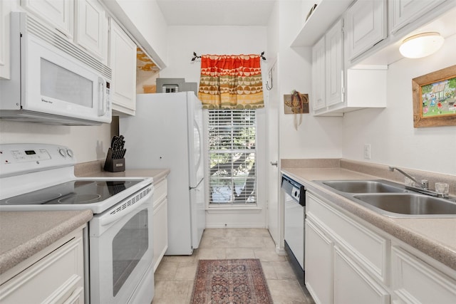 kitchen with sink, white cabinets, white appliances, and light tile patterned floors