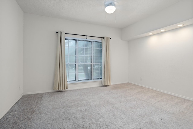 carpeted empty room featuring a textured ceiling