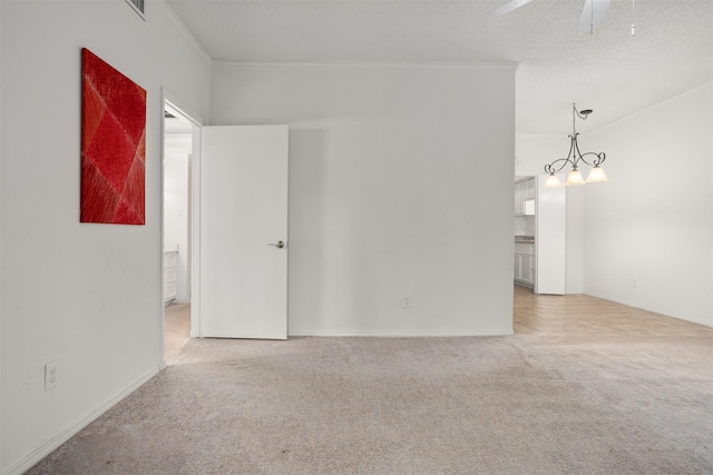 carpeted empty room featuring crown molding, ceiling fan, and a textured ceiling