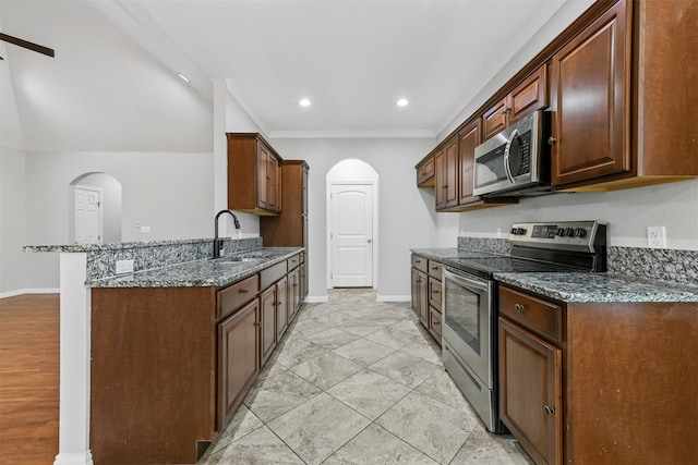 kitchen featuring kitchen peninsula, appliances with stainless steel finishes, ornamental molding, sink, and dark stone countertops