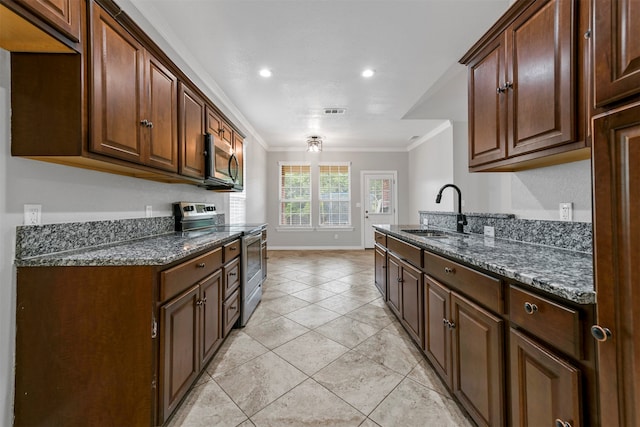 kitchen with appliances with stainless steel finishes, dark stone counters, crown molding, sink, and light tile patterned floors