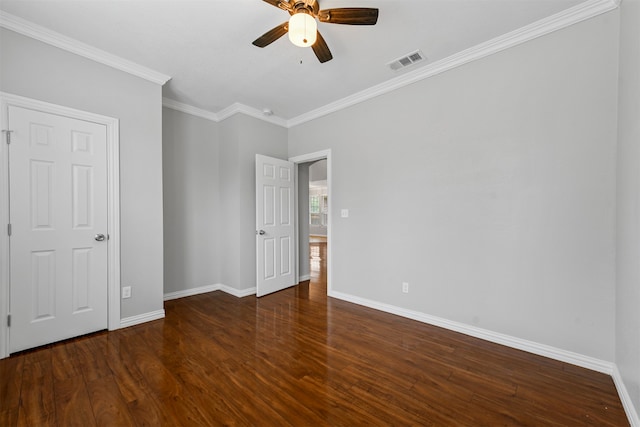 unfurnished bedroom with ceiling fan, ornamental molding, and dark wood-type flooring