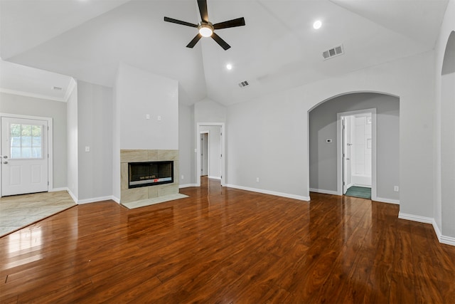 unfurnished living room featuring a tile fireplace, wood-type flooring, high vaulted ceiling, and ceiling fan