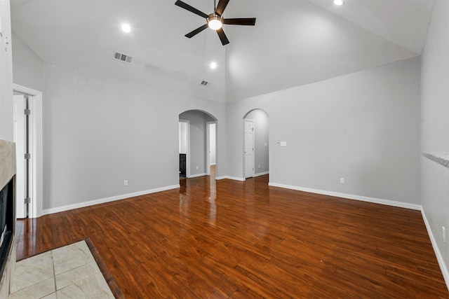 unfurnished living room with ceiling fan, wood-type flooring, a fireplace, and high vaulted ceiling