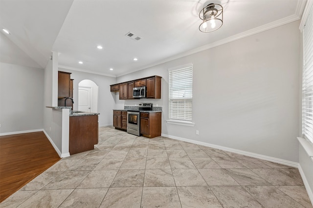 kitchen with light stone counters, crown molding, and stainless steel appliances