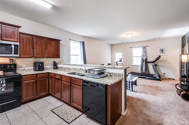 kitchen with light carpet, black appliances, a sink, a peninsula, and light stone countertops