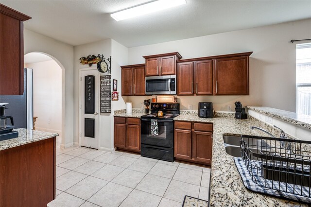 kitchen featuring black range with electric cooktop, light stone counters, and light tile patterned floors