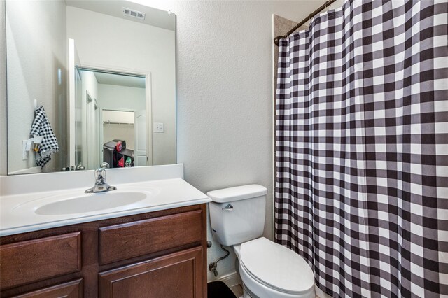 full bathroom with visible vents, toilet, a shower with curtain, a textured wall, and vanity