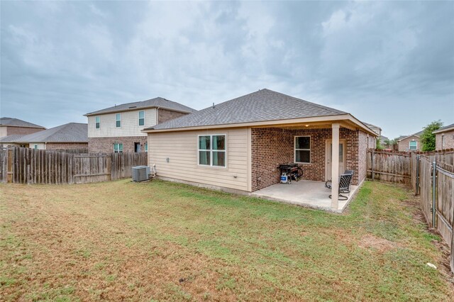 back of house featuring a lawn, a patio, and central AC unit