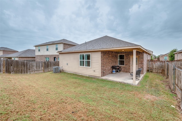 rear view of house with a yard, a patio area, brick siding, and a fenced backyard