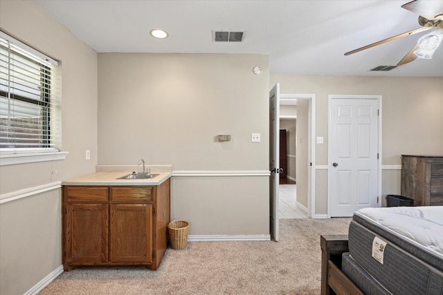 interior space featuring light colored carpet, sink, and ceiling fan