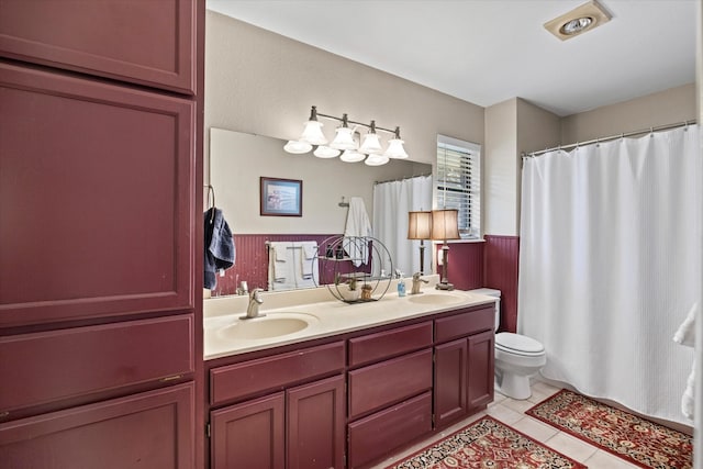 bathroom featuring tile patterned flooring, toilet, and vanity