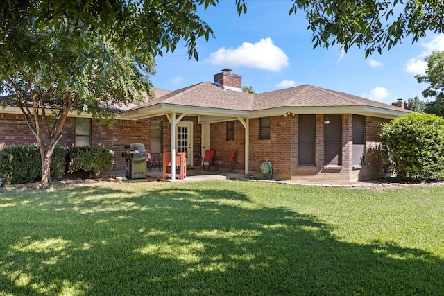 rear view of property featuring a yard and a patio