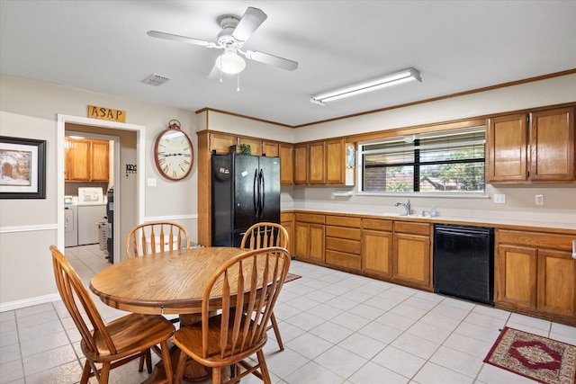 kitchen featuring light tile patterned floors, black appliances, washing machine and dryer, sink, and ceiling fan