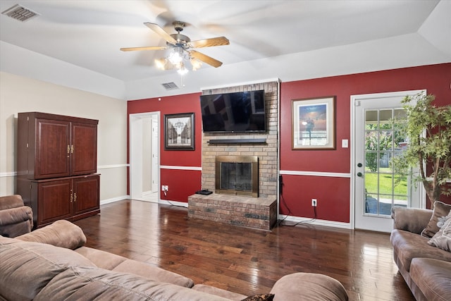 living room featuring ceiling fan, dark hardwood / wood-style floors, vaulted ceiling, and a fireplace