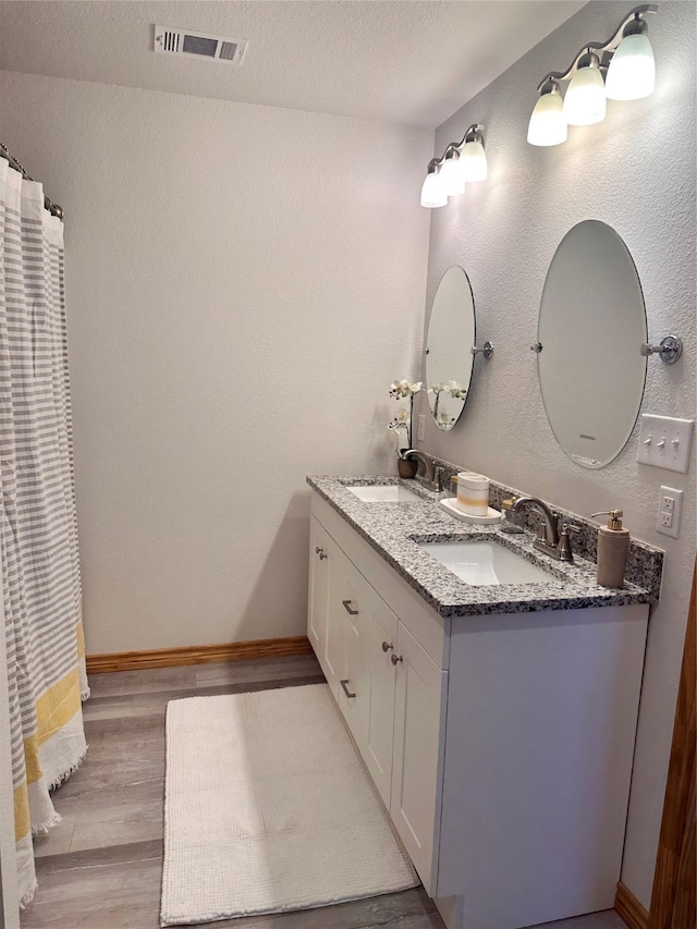 bathroom featuring a textured ceiling, hardwood / wood-style flooring, and vanity