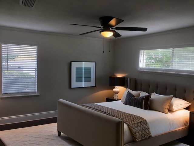 bedroom featuring ceiling fan, ornamental molding, and hardwood / wood-style flooring