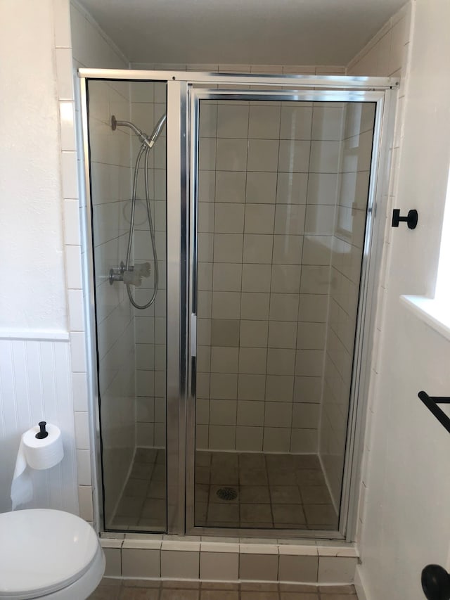 bathroom with toilet and an enclosed shower