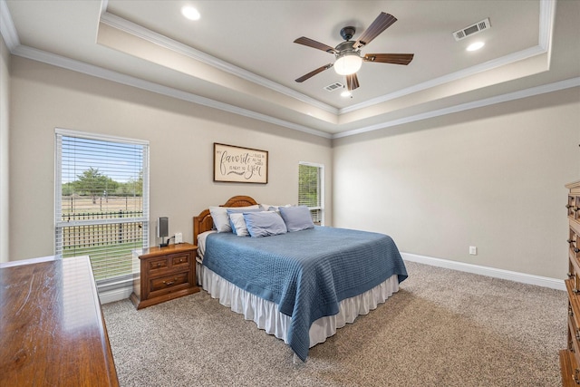 bedroom featuring multiple windows, visible vents, and a raised ceiling