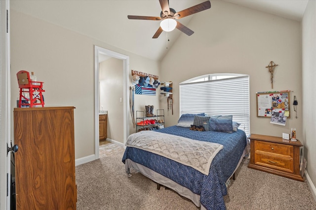 bedroom featuring light carpet, baseboards, ceiling fan, ensuite bathroom, and high vaulted ceiling