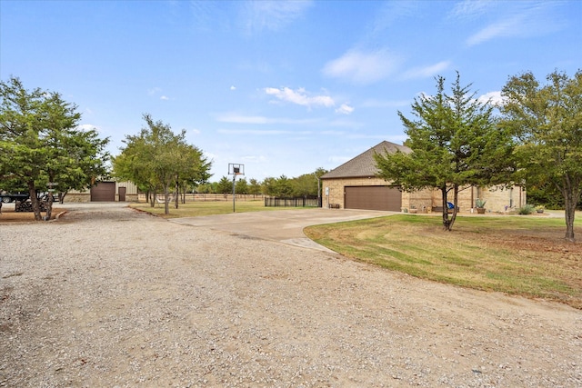 view of front of house featuring a garage, driveway, fence, a front lawn, and brick siding