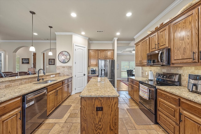 kitchen with stainless steel appliances, stone tile flooring, a sink, and light stone counters