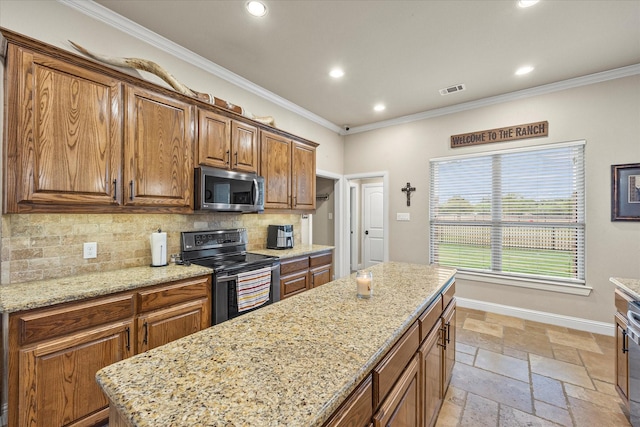 kitchen featuring crown molding, stone tile floors, stainless steel appliances, backsplash, and baseboards