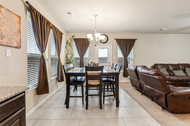 tiled dining room with an inviting chandelier