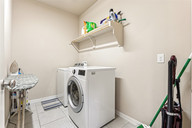 clothes washing area with washer and dryer and light tile patterned floors