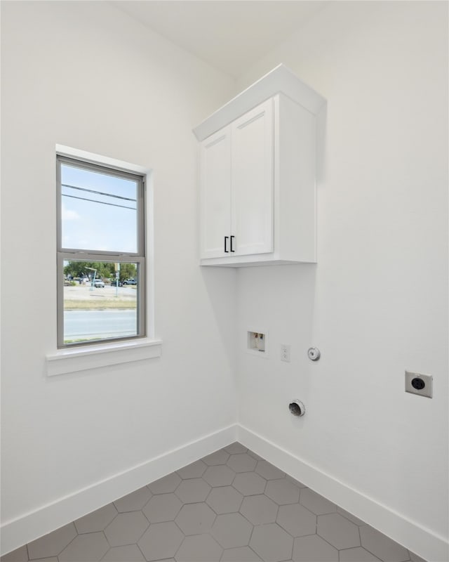 washroom with washer hookup, tile patterned flooring, hookup for an electric dryer, and cabinets