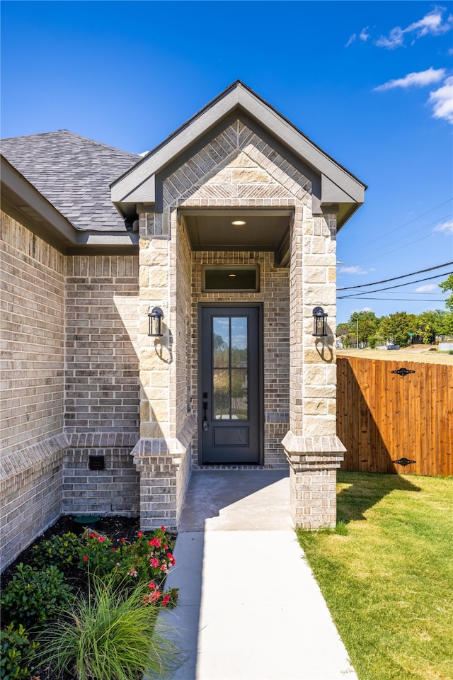 doorway to property featuring a lawn