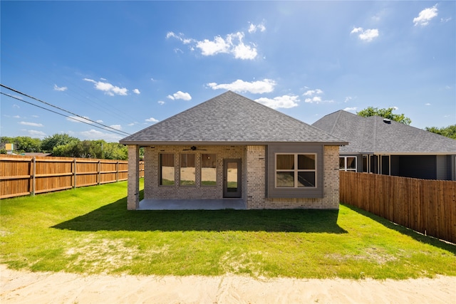 back of house with a yard and a patio