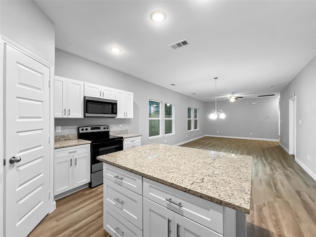 kitchen with a kitchen island, stainless steel appliances, light wood-type flooring, and white cabinets