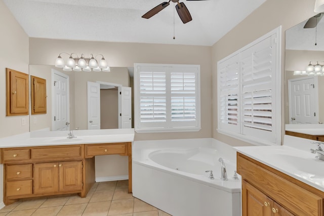 bathroom with a textured ceiling, a tub, vanity, tile patterned flooring, and ceiling fan