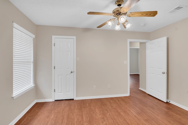 unfurnished bedroom with a textured ceiling, ceiling fan, and light hardwood / wood-style floors