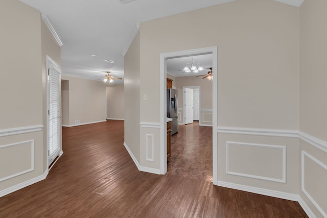 corridor with dark hardwood / wood-style floors, a chandelier, and crown molding