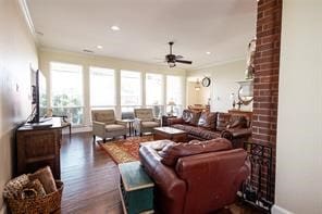 living room featuring plenty of natural light, ceiling fan, ornamental molding, and dark hardwood / wood-style flooring