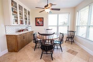 dining space featuring baseboards, light tile patterned flooring, and a ceiling fan