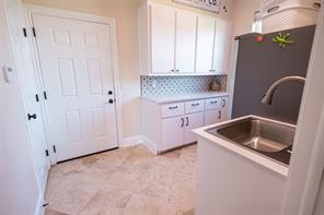 kitchen featuring a sink, decorative backsplash, and white cabinetry