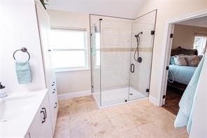 bathroom featuring a healthy amount of sunlight, vaulted ceiling, vanity, and walk in shower