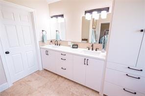 full bathroom with a sink and double vanity