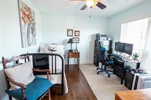 office space featuring a ceiling fan, wood finished floors, baseboards, and a wealth of natural light