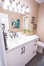 bathroom with vanity, toilet, and a chandelier