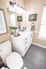 bathroom with toilet, plenty of natural light, and vanity