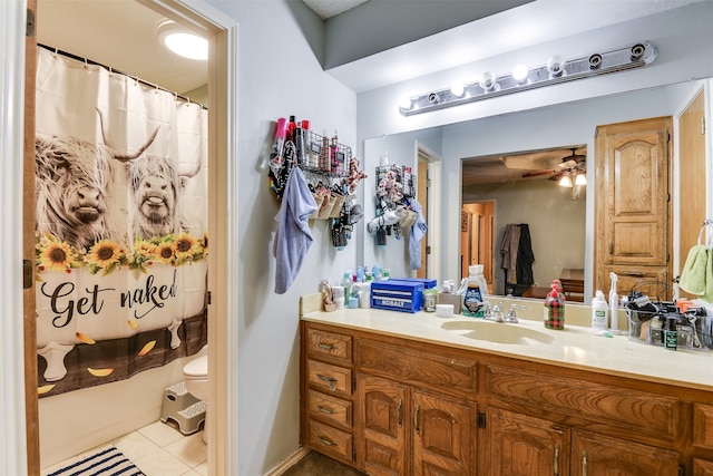 bathroom featuring tile patterned flooring, toilet, ceiling fan, vanity, and curtained shower