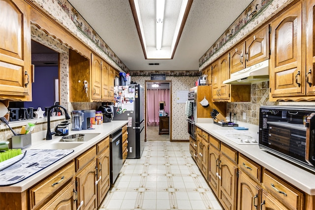 kitchen with a textured ceiling, appliances with stainless steel finishes, and sink