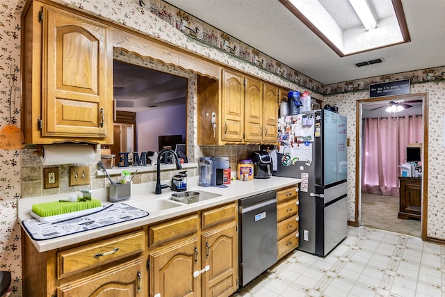 kitchen featuring ceiling fan, a textured ceiling, appliances with stainless steel finishes, and sink