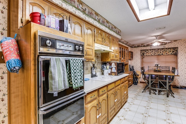 kitchen with a textured ceiling, double oven, ceiling fan, and white electric stovetop